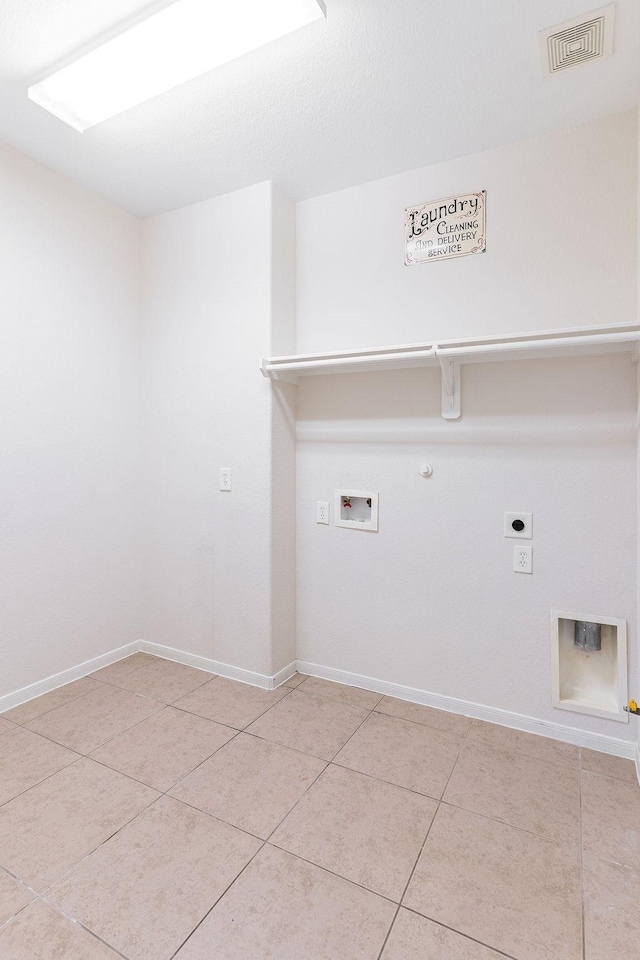 washroom with gas dryer hookup, hookup for an electric dryer, washer hookup, light tile patterned floors, and baseboards