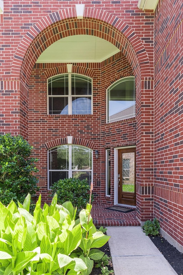 view of exterior entry with brick siding