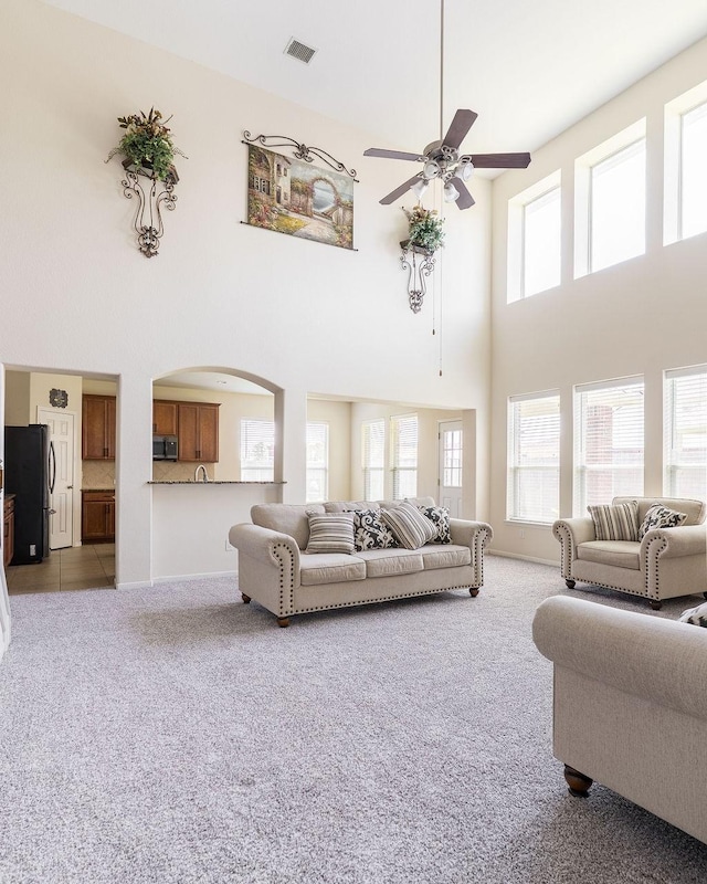 13907 Falling Rain Ct, Cypress, TX 77429 - living area with a towering ceiling, carpet, a ceiling fan, and arched walkways
