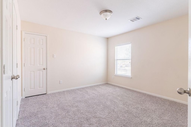 carpeted empty room featuring baseboards