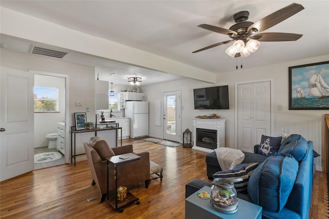 1619 Fm 517th Rd E, San Leon, TX 77539 - living area with wood finished floors, a ceiling fan, and a fireplace