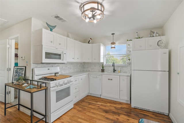 1619 Fm 517th Rd E, San Leon, TX 77539 - kitchen with white appliances, a sink, decorative backsplash, light wood-style flooring, and white cabinets
