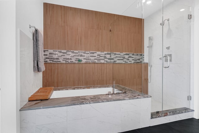 full bathroom featuring a shower stall and a garden tub