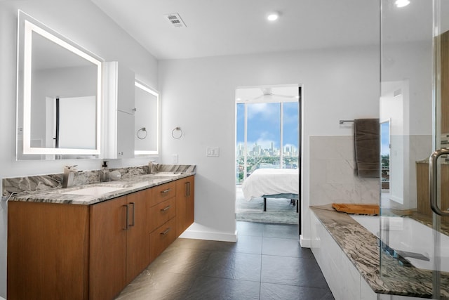 full bathroom featuring double vanity, a skyline view, connected bathroom, baseboards, and ceiling fan