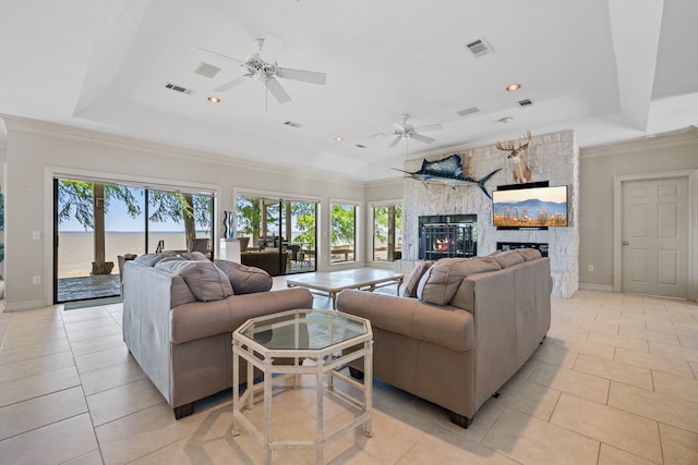 180 Hummel Ln, Coldspring, TX 77331 - living room featuring a stone fireplace, a raised ceiling, a ceiling fan, crown molding, and recessed lighting