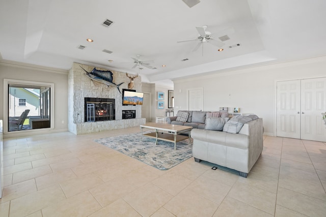 180 Hummel Ln, Coldspring, TX 77331 - living room with a tray ceiling, a ceiling fan, a fireplace, crown molding, and light tile patterned floors