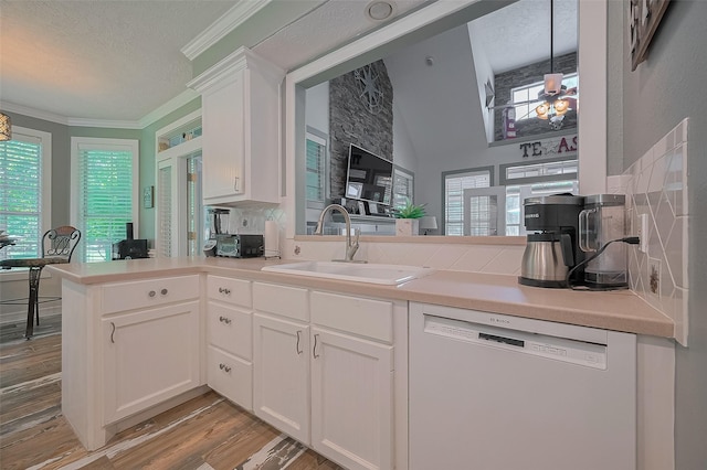 8946 Catamaran Way, Montgomery, TX 77316 - kitchen featuring white dishwasher, a sink, a peninsula, a textured ceiling, and light wood-style floors