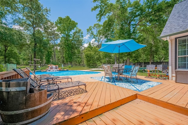 8946 Catamaran Way, Montgomery, TX 77316 - swimming pool with a wooden deck, a fenced backyard, outdoor dining space, and view of scattered trees