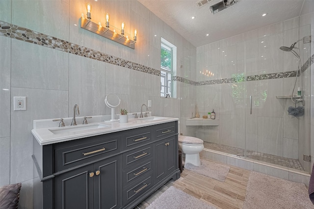 8946 Catamaran Way, Montgomery, TX 77316 - full bath featuring tile walls, a shower stall, wood finished floors, toilet, and double vanity