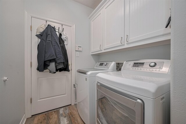 8946 Catamaran Way, Montgomery, TX 77316 - laundry area featuring cabinet space, washing machine and clothes dryer, and wood finished floors