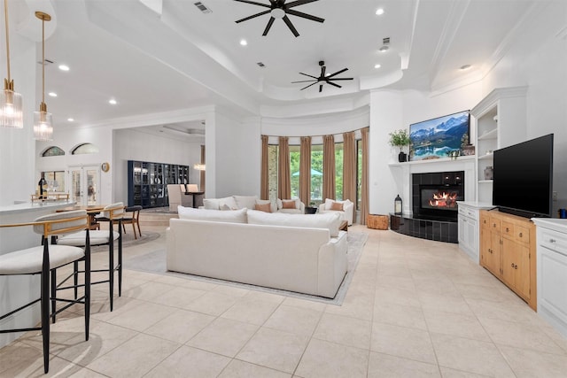 3706 Skyoak Ct, Spring, TX 77386 - living area featuring ornamental molding, a ceiling fan, a tile fireplace, recessed lighting, and a tray ceiling