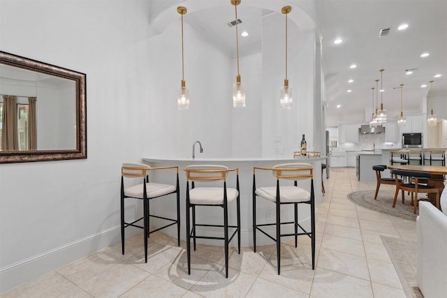 3706 Skyoak Ct, Spring, TX 77386 - kitchen with a kitchen breakfast bar, white cabinetry, light tile patterned floors, recessed lighting, and pendant lighting