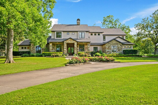 7527 Foster Island Dr, Richmond, TX 77406 - view of front of property with stone siding, a chimney, a front lawn, and stucco siding