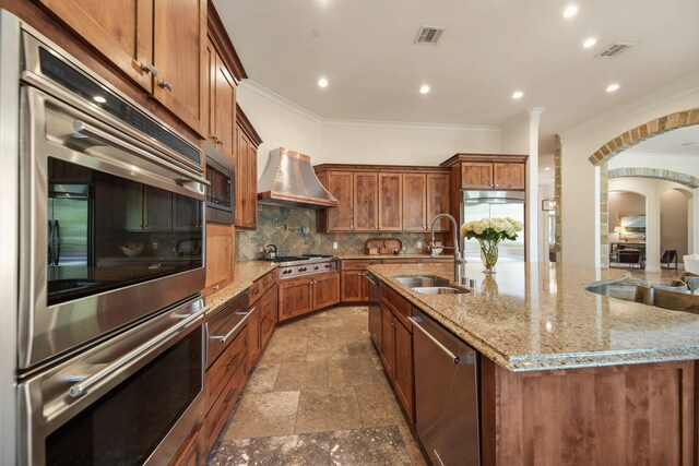 7527 Foster Island Dr, Richmond, TX 77406 - kitchen featuring a sink, appliances with stainless steel finishes, custom range hood, crown molding, and tasteful backsplash