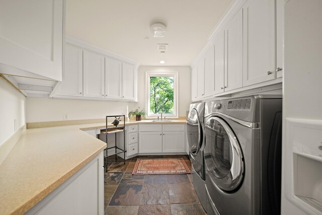 7527 Foster Island Dr, Richmond, TX 77406 - washroom featuring washer and clothes dryer, cabinet space, and dark stone finish flooring