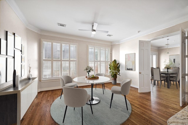 dining area featuring dark wood finished floors, ceiling fan, baseboards, and ornamental molding