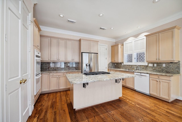 kitchen featuring appliances with stainless steel finishes, a kitchen island, ornamental molding, tasteful backsplash, and dark wood finished floors