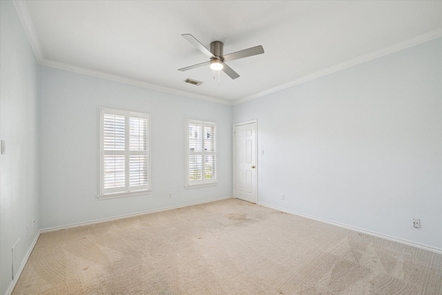 empty room with ornamental molding, ceiling fan, light colored carpet, and baseboards
