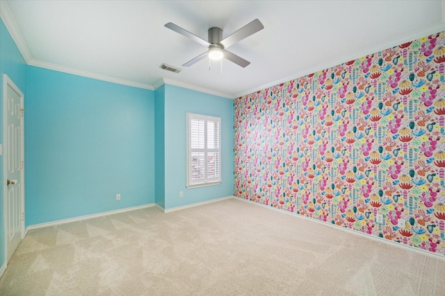 spare room featuring ornamental molding, a ceiling fan, carpet flooring, and baseboards
