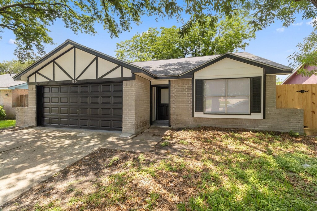 4904 Deerwood Cir, Baytown, TX 77521 - view of front of property featuring brick siding, driveway, an attached garage, fence, and roof with shingles