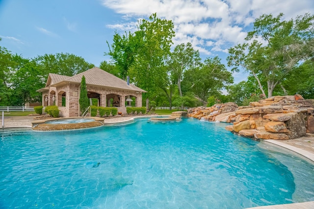 18518 W Paloma Lago Cir, Cypress, TX 77433 - view of pool featuring a gazebo, fence, a pool with connected hot tub, and view of scattered trees