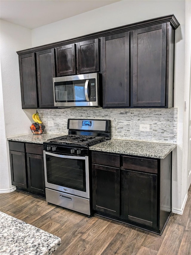 18475 Tenaha Mill Dr, New Caney, TX 77357 - kitchen featuring appliances with stainless steel finishes, dark wood-type flooring, and tasteful backsplash