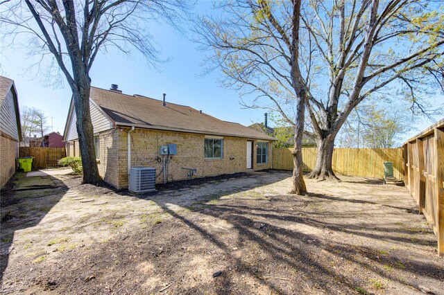 2036 Woodland Hills Dr, Missouri City, TX 77489 - back of property with brick siding, a fenced backyard, and central air condition unit