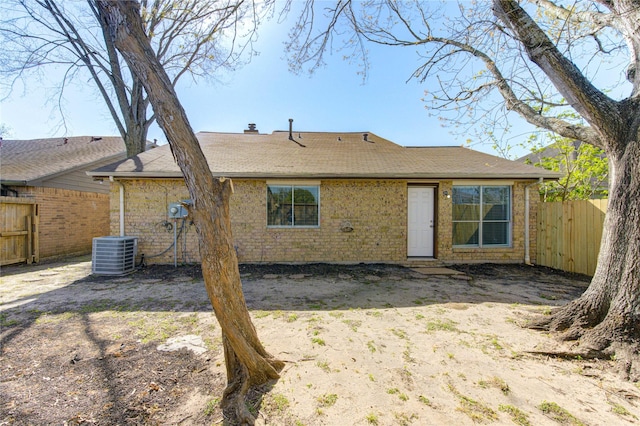 2036 Woodland Hills Dr, Missouri City, TX 77489 - back of property with central air condition unit, brick siding, and roof with shingles