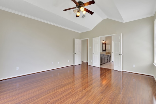 unfurnished bedroom with lofted ceiling, baseboards, wood finished floors, and ornamental molding