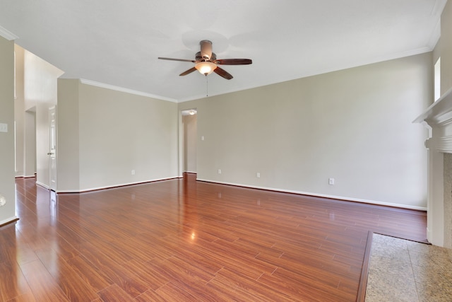 unfurnished living room featuring ceiling fan, a fireplace, ornamental molding, wood finished floors, and baseboards
