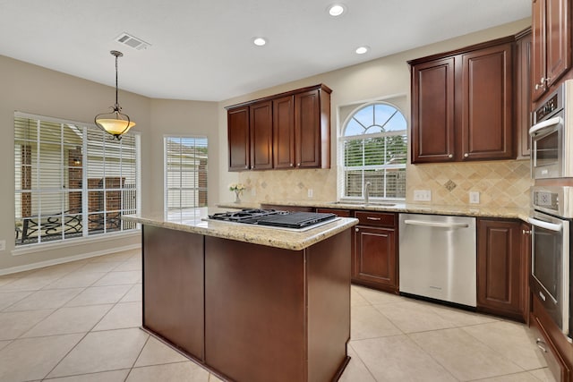 kitchen featuring stainless steel appliances, plenty of natural light, decorative backsplash, recessed lighting, and light stone countertops