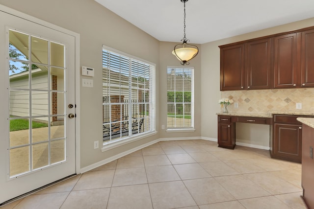 unfurnished dining area featuring light tile patterned floors and baseboards