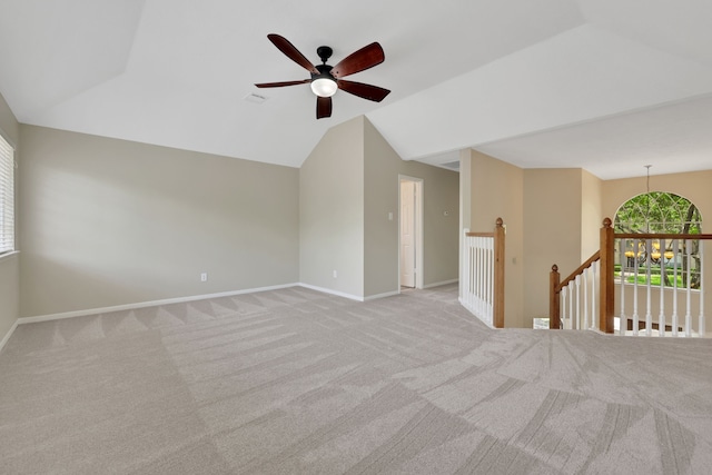 spare room with carpet floors, a ceiling fan, vaulted ceiling, and baseboards