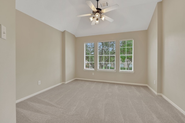 carpeted empty room featuring baseboards, a ceiling fan, and vaulted ceiling