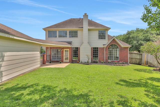 back of house with brick siding, a patio, a chimney, and a shingled roof