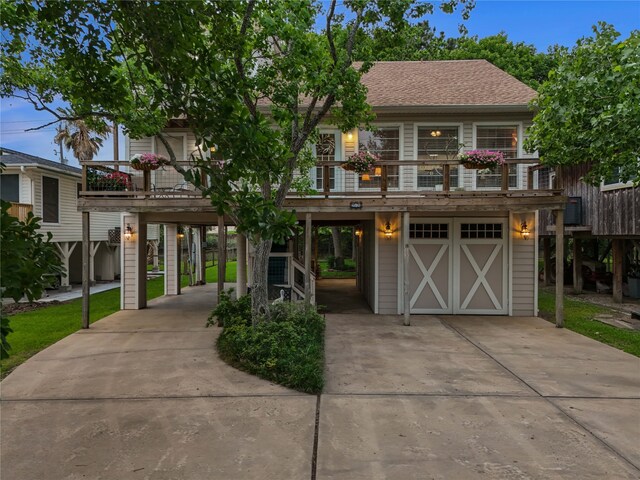 268 Seminole Dr, League City, TX 77565 - coastal inspired home featuring a carport, concrete driveway, an attached garage, and roof with shingles