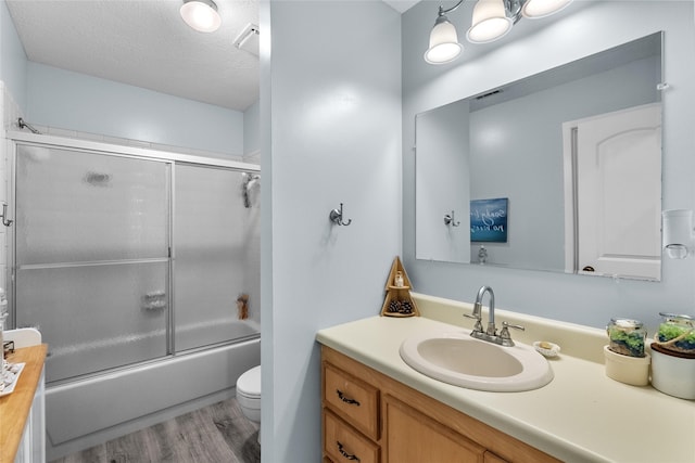 268 Seminole Dr, League City, TX 77565 - bathroom with vanity, toilet, wood finished floors, enclosed tub / shower combo, and a textured ceiling