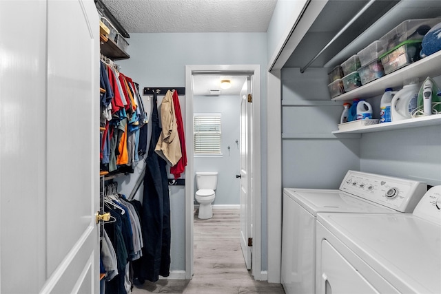 268 Seminole Dr, League City, TX 77565 - laundry room featuring washing machine and dryer, light wood-style floors, and a textured ceiling