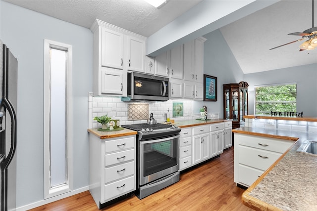 268 Seminole Dr, League City, TX 77565 - kitchen featuring stainless steel appliances, light wood-style floors, white cabinetry, a ceiling fan, and vaulted ceiling