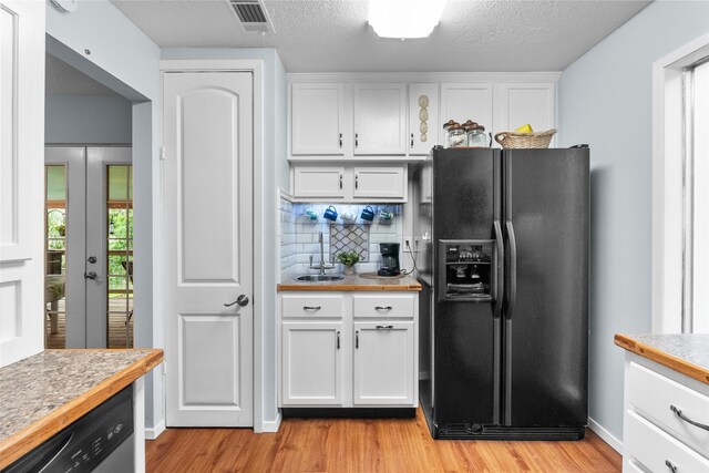268 Seminole Dr, League City, TX 77565 - kitchen featuring black refrigerator with ice dispenser, a sink, light wood-style flooring, white cabinets, and a textured ceiling