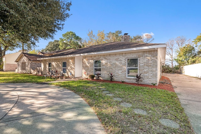 7735 Antoine Dr, Houston, TX 77088 - ranch-style house featuring a chimney, a front lawn, a patio area, and brick siding