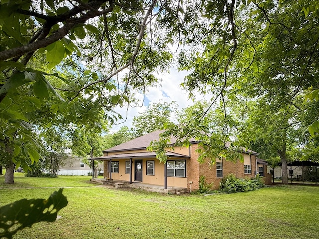 102 Besch Wilburn Ln, Glidden, TX 78943 - back of house featuring a lawn, covered porch, and brick siding