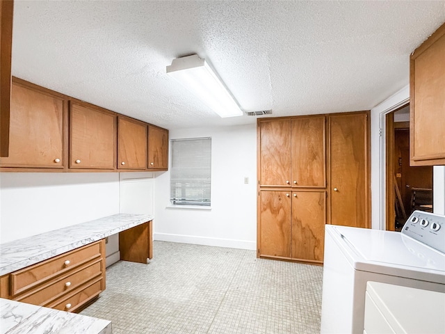 102 Besch Wilburn Ln, Glidden, TX 78943 - laundry room with cabinet space, separate washer and dryer, a textured ceiling, a desk, and baseboards