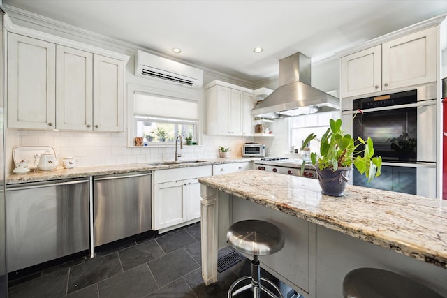 1755 Kipling St, Houston, TX 77098 - kitchen featuring a sink, island exhaust hood, a wall mounted AC, stainless steel appliances, and a kitchen breakfast bar