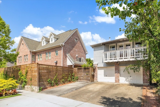 1755 Kipling St, Houston, TX 77098 - view of front of property with brick siding, a garage, driveway, a balcony, and fence