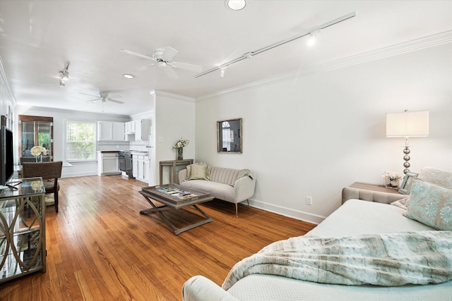 1755 Kipling St, Houston, TX 77098 - living room featuring rail lighting, crown molding, baseboards, wood finished floors, and a ceiling fan