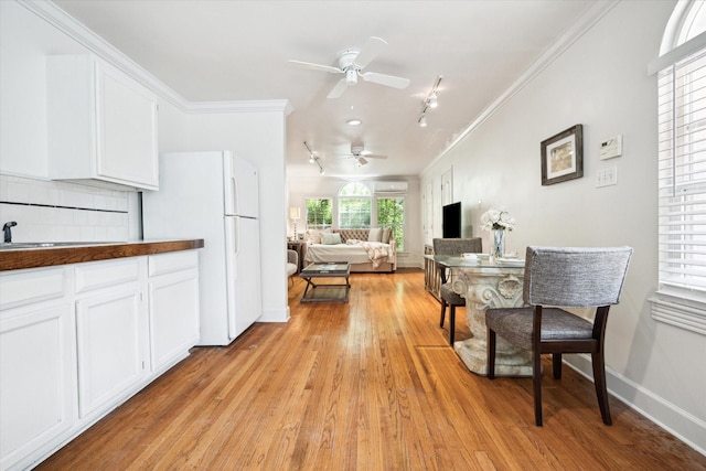1755 Kipling St, Houston, TX 77098 - kitchen featuring a ceiling fan, freestanding refrigerator, crown molding, light wood finished floors, and a sink