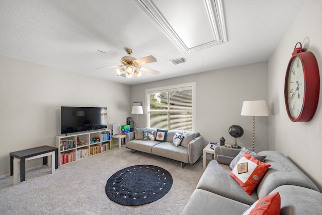 living area featuring attic access, carpet floors, and ceiling fan