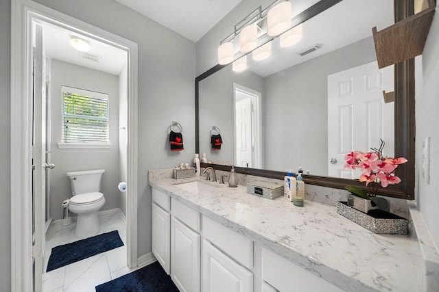 bathroom featuring marble look tile flooring, vanity, toilet, and baseboards