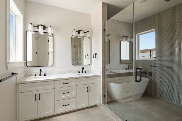 3224 Omega St, Houston, TX 77022 - bathroom with a freestanding bath, double vanity, tile patterned floors, tile walls, and a walk in shower
